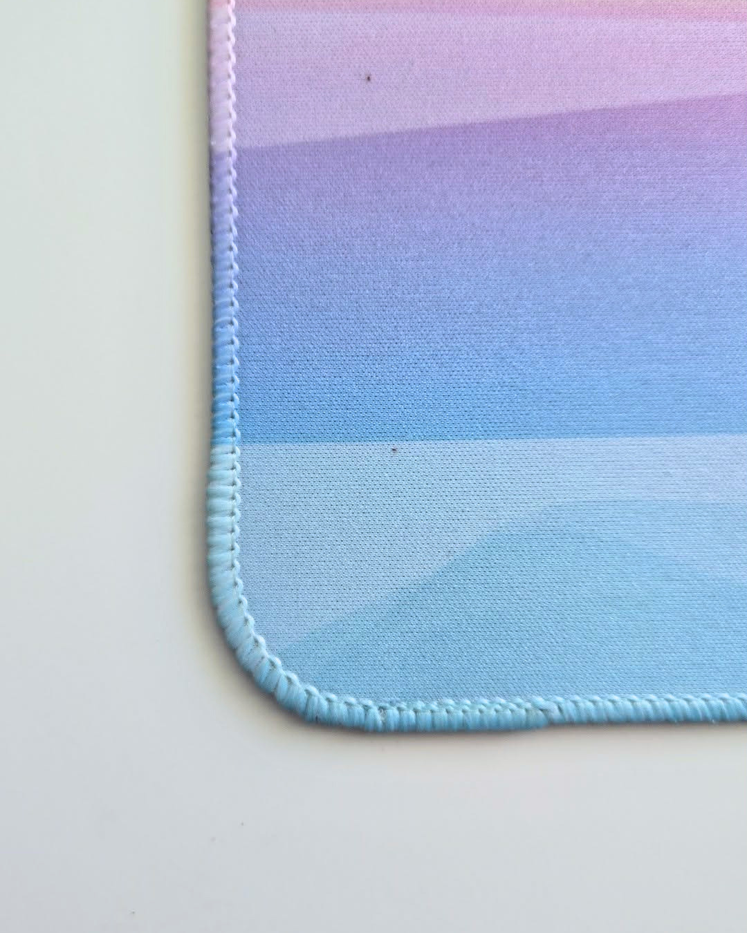 close up a mousepad with embroidered stitch edging