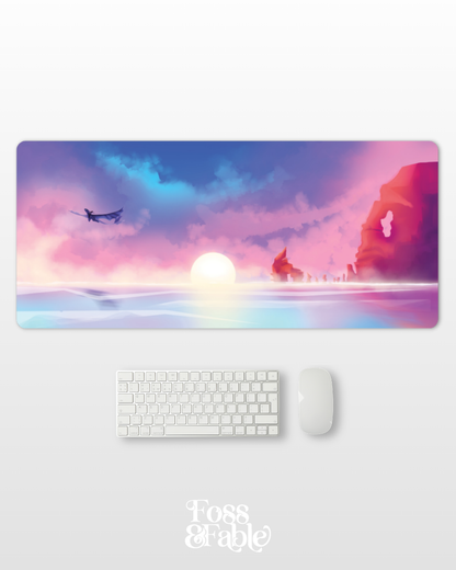 Desk setup with a large decorative mouse pad featuring a sunset design, keyboard, and mouse on a white surface.